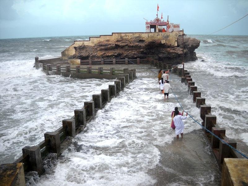 Arabian Sea waves crashing around the rocky base of Bhadkeshwar Mahadev Temple in Dwarka.