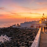 Bhadkeshwar Mahadev Temple in Dwarka, Gujarat, surrounded by the Arabian Sea during sunset.