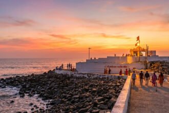Bhadkeshwar Mahadev Temple in Dwarka, Gujarat, surrounded by the Arabian Sea during sunset.