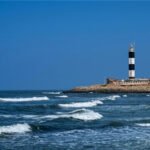 Dwarka Lighthouse in Gujarat overlooking the Arabian Sea and the Dwarkadhish Temple skyline