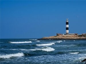 Dwarka Lighthouse in Gujarat overlooking the Arabian Sea and the Dwarkadhish Temple skyline