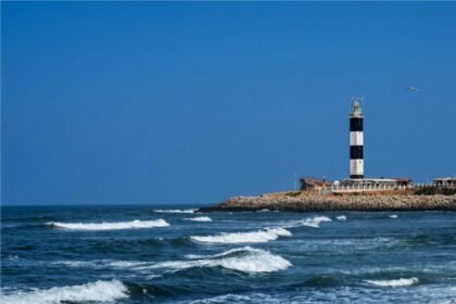 Dwarka Lighthouse in Gujarat overlooking the Arabian Sea and the Dwarkadhish Temple skyline