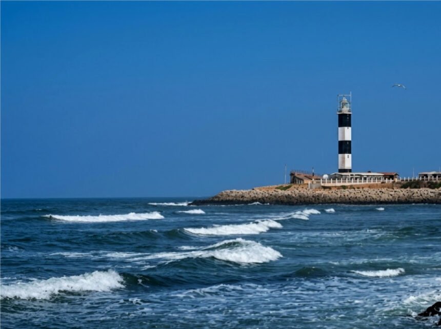 Dwarka Lighthouse in Gujarat overlooking the Arabian Sea and the Dwarkadhish Temple skyline